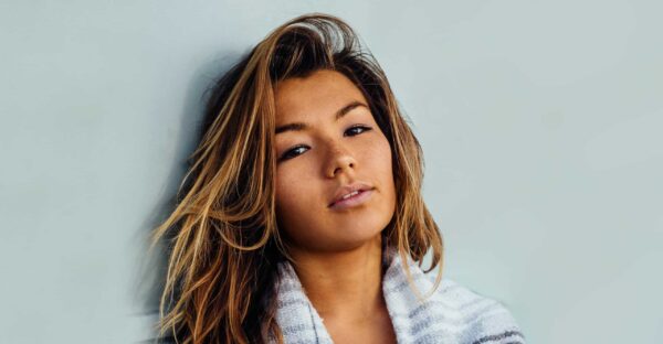 woman with highlights leaning against a wall